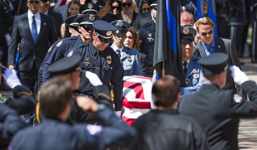 The casket of Phoenix Police Officer David Glasser is taken into Christ's Church of the Valley in Peoria Thursday, May 26, 2016, for his funeral service. Glasser died May 19, a day after he was wounded when shot by a burglary suspect who then was fatally shot by police. (Tom Tingle/The Arizona Republic via AP) MARICOPA COUNTY OUT; MAGS OUT; NO SALES; MANDATORY CREDIT MBO