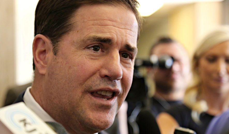 Arizona Gov. Doug Ducey talks with reporters after certifying the results of a special election on school funding and police and fire pension measures at the state Capitol in Phoenix on Thursday, May 26, 2016. (AP Photo/Ryan Van Velzer)