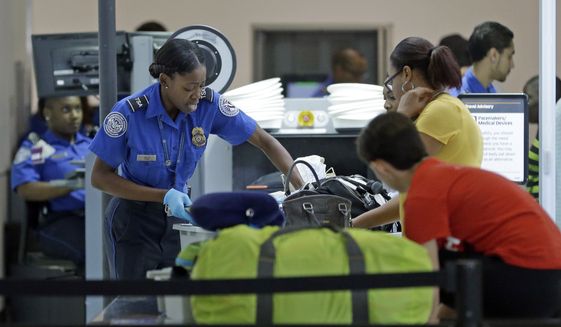 A Transportation Security Administration officer checks travelers luggage to be screened by an x-ray machine at a checkpoint at Fort Lauderdale-Hollywood International Airport, Friday, May 27, 2016, in Fort Lauderdale, Fla. (AP Photo/Alan Diaz)