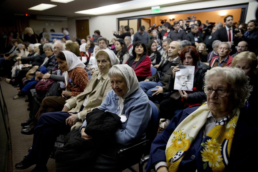 People sit in federal court for the sentencing of former military officers in Buenos Aires, Argentina, Friday, May 27, 2016. The court will deliver a sentence on a long-awaited human rights trial focused on Operation Condor, a secret conspiracy launched by six South American dictators in the 1970s in a combined effort to track down their enemies and eliminate them. (AP Photo/Natacha Pisarenko)