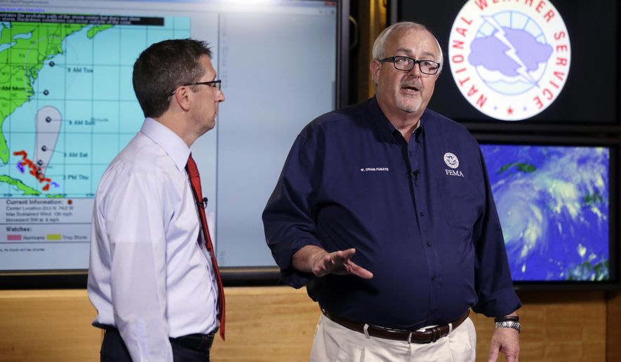 FILE- In this Oct.1, 2015 file photo, Craig Fugate, Administrator of the Federal Emergency Management Agency (FEMA), right, talks about the status of Hurricane Joaquin as it moves through the eastern Bahamas as Rick Knabb, Director of the National Hurricane Center, left, participate in a media briefing at the National Hurricane Center. The U.S. government is set to release its forecast for how many hurricanes and tropical storms are expected to form over Atlantic and Caribbean waters in the next six months. It’s an annual reminder from the National Oceanic and Atmospheric Administration that coastal living comes with significant risks. (AP Photo/Lynne Sladky, File)