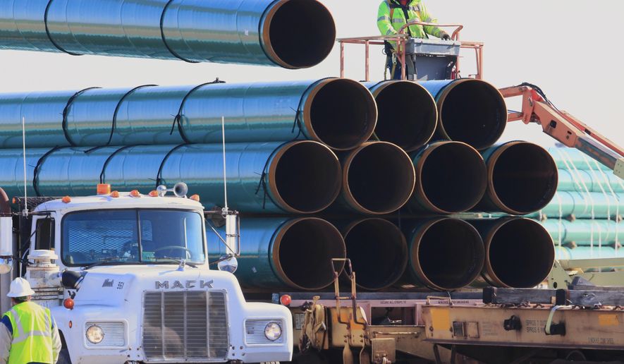 FILE - In this May 9, 2015, file photo, workers unload pipes for the proposed Dakota Access oil pipeline that would stretch from the Bakken oil fields in North Dakota to Illinois. The discovery of a possible American Indian burial site in northwest Iowa may require relocation of a crude oil pipeline route which would further delay the beginning of construction in Iowa, the only one of four states where work hasn&#39;t yet begun. The Dakota Access pipeline passes through the Big Sioux Wildlife Management area in Lyon County where an American Indian tribe said it has a burial site. (AP Photo/Nati Harnik, File)