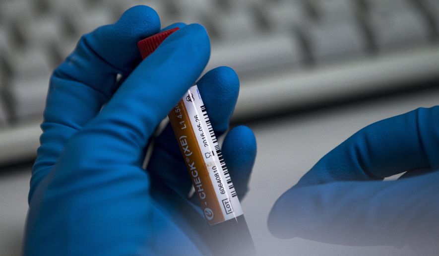 An employee of the Russia&#39;s national drug-testing laboratory holds a vial in Moscow, Russia, Tuesday, May 24, 2016. (AP Photo/Alexander Zemlianichenko) **FILE**