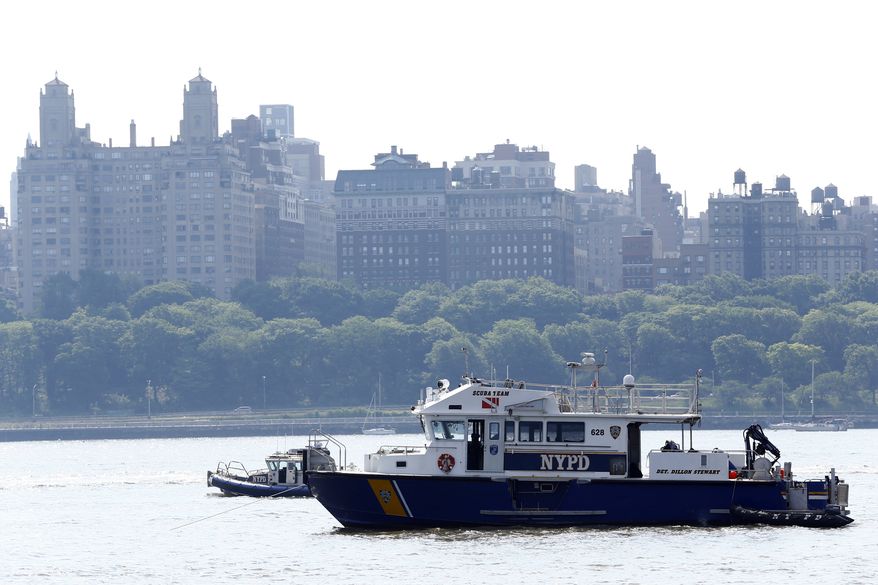 NYPD search and rescue boats sit on the Hudson River near the site of small plane crash, Saturday, May 28, 2016, in North Bergen, N.J. A World War II vintage P-47 Thunderbolt aircraft crashed into the river Friday, May 27, 2016, killing its pilot. (AP Photo/Julio Cortez)