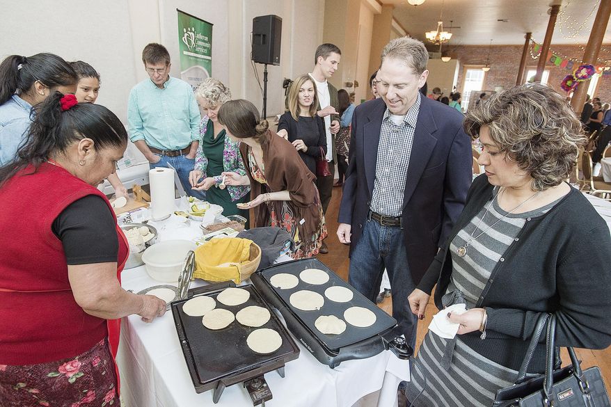 ADVANCE FOR WEEKEND EDITIONS - In this May 21, 2016 photo, Michael Hampton waits patiently as the tortilla he made cooks on the hot plate in McMinnville, Ore. Making fresh tortillas was one of the activities guests enjoyed at the Fiesta in La Plaza event over the weekend. (Marcus Larson/News-Register via AP) MANDATORY CREDIT
