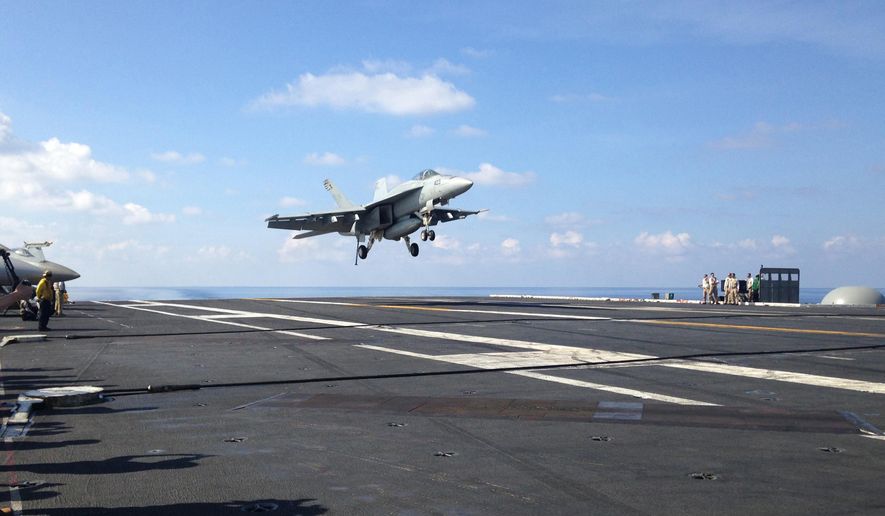 FILE - In this Friday, April 15, 2016 file photo, an FA-18 jet fighter lands on the USS John C. Stennis aircraft carrier in the South China Sea while U.S. Defense Secretary Ash Carter visited the aircraft carrier during a trip to the region. American ships and fighter jets maneuvering across the South China Sea and the Sea of Japan represent the “new normal” in U.S.-Pacific relations despite rising tensions with China and Russia. U.S. moves in recent months have led to angry protests from Beijing and Moscow. They say the Obama administration is fueling unrest in the Asia Pacific, and is conducting for illegal and unsafe transit in the region. (AP Photo/Lolita C. Baldor, File)