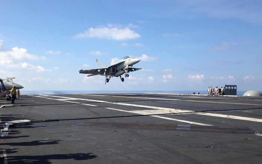 FILE - In this Friday, April 15, 2016 file photo, an FA-18 jet fighter lands on the USS John C. Stennis aircraft carrier in the South China Sea while U.S. Defense Secretary Ash Carter visited the aircraft carrier during a trip to the region. American ships and fighter jets maneuvering across the South China Sea and the Sea of Japan represent the “new normal” in U.S.-Pacific relations despite rising tensions with China and Russia. U.S. moves in recent months have led to angry protests from Beijing and Moscow. They say the Obama administration is fueling unrest in the Asia Pacific, and is conducting for illegal and unsafe transit in the region. (AP Photo/Lolita C. Baldor, File)