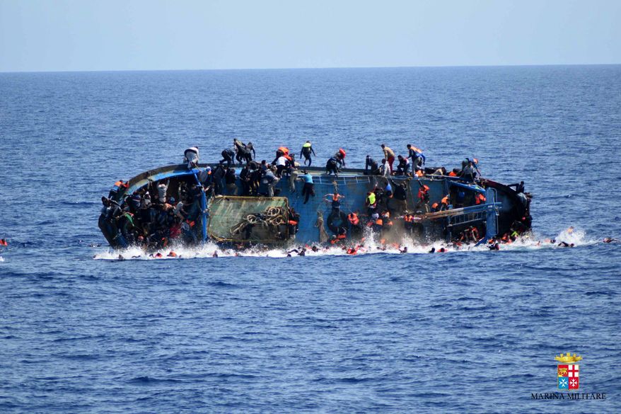 In this May 25, 2016, file photo made available by the Italian Navy, people try to jump in the water right before their boat overturns off the Libyan coast. Over 700 migrants are feared dead in three Mediterranean Sea shipwrecks south of Italy in the last few days as they tried desperately to reach Europe in unseaworthy smuggling boats, the U.N. refugee agency said Sunday, May 29, 2016. (Italian navy via AP Photo, file)