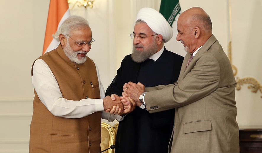 From left, Indian Prime Minister Narendra Modi, Iranian President Hassan Rouhani and Afghan President Ashraf Ghani hold hands in a show of solidarity after their trilateral meeting at the Saadabad Palace in Tehran, Iran, on May 23. (Iranian Presidency Office via Associated Press)