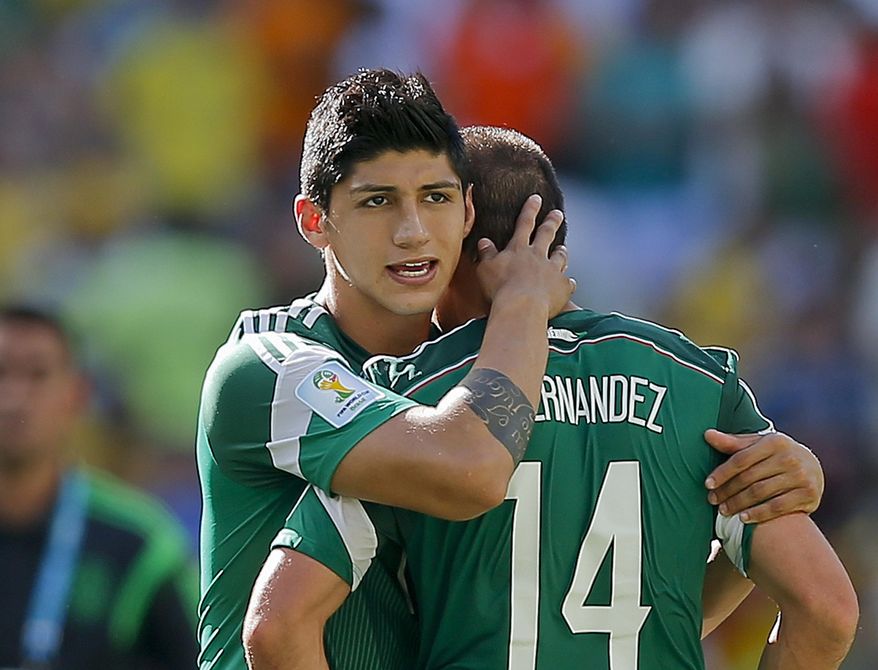 In a June 29, 2014, file photo, Mexico's Alan Pulido consoles teammate Javier Hernandez (14) after the Netherlands defeated Mexico 2-1 during the World Cup round of 16 soccer match between the Netherlands and Mexico at the Arena Castelao in Fortaleza, Brazil. (AP Photo/Eduardo Verdugo, File)