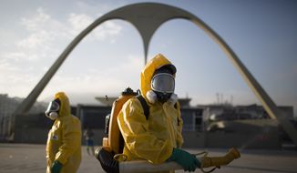 In this Tuesday, Jan. 26, 2016, file photo, a health workers stands in the Sambadrome spraying insecticide to combat the Aedes aegypti mosquito that transmits the Zika virus in Rio de Janeiro, Brazil. (AP Photo/Leo Correa, File)