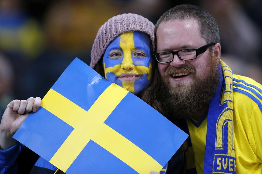 FILE - In this Tuesday, Nov. 19, 2013 file photo, Sweden fans pose with a Swedish flag before the World Cup qualifying soccer match between Sweden and Portugal in Stockholm, Sweden. For the first time since record-keeping began in 1749, Sweden now has more men than women. Swedes don't quite know what to make of this sudden male surplus, which is highly unusual in the West, where women historically have been in the majority in almost every country. But it may be a sign of things to come in Europe as changes in life expectancy and migration transform demographics. The tipping point in Sweden happened in March 2015, when population statistics showed 277 more men than women. (AP Photo/Frank Augstein, file)