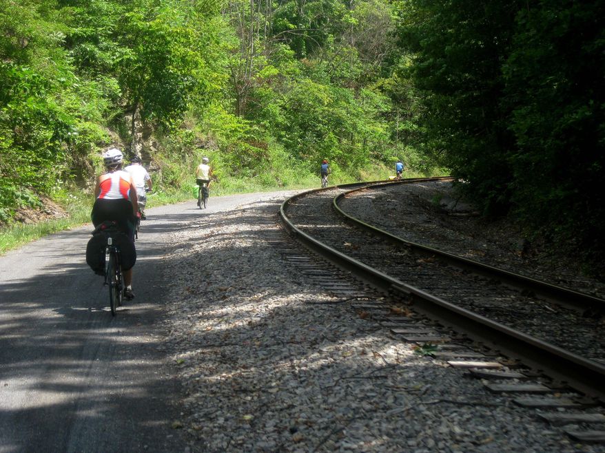 FILE - In this July 14, 2012, file photo, bicyclists finishing a three-day ride of the Great Allegheny Passage between Pittsburgh and Cumberland, Md., enter a downhill section of the trail near Cumberland, Md. As the national Rails-to-Trails Conservancy marks its 30th anniversary in 2016, Pennsylvania's rail trails, ranging from local trails a few miles long to the 150-mile Great Allegheny Passage, are among 1,970 trails nationwide that cover more than 22,300 miles. (AP Photo/Cal Woodward, File)