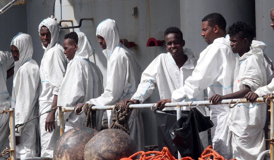 In this photo taken Sunday, May 29, 2016 migrants attend to disembark from the Italian Navy Vega vessel, in Reggio Calabria, southern Italy, after being rescued in the Mediterranean Sea off the coasts of Libya. Survivor accounts have pushed to more than 700 the number of migrants feared dead in Mediterranean Sea shipwrecks over three days in the past week, even as rescue ships saved thousands of others in daring operations. (AP Photo/Adriana Sapone)