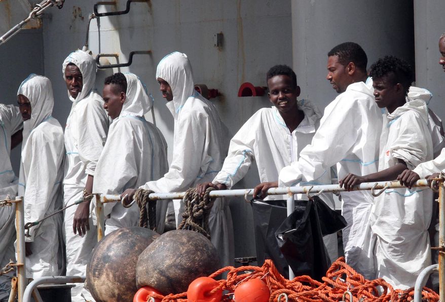 In this photo taken Sunday, May 29, 2016 migrants attend to disembark from the Italian Navy Vega vessel, in Reggio Calabria, southern Italy, after being rescued in the Mediterranean Sea off the coasts of Libya. Survivor accounts have pushed to more than 700 the number of migrants feared dead in Mediterranean Sea shipwrecks over three days in the past week, even as rescue ships saved thousands of others in daring operations. (AP Photo/Adriana Sapone)