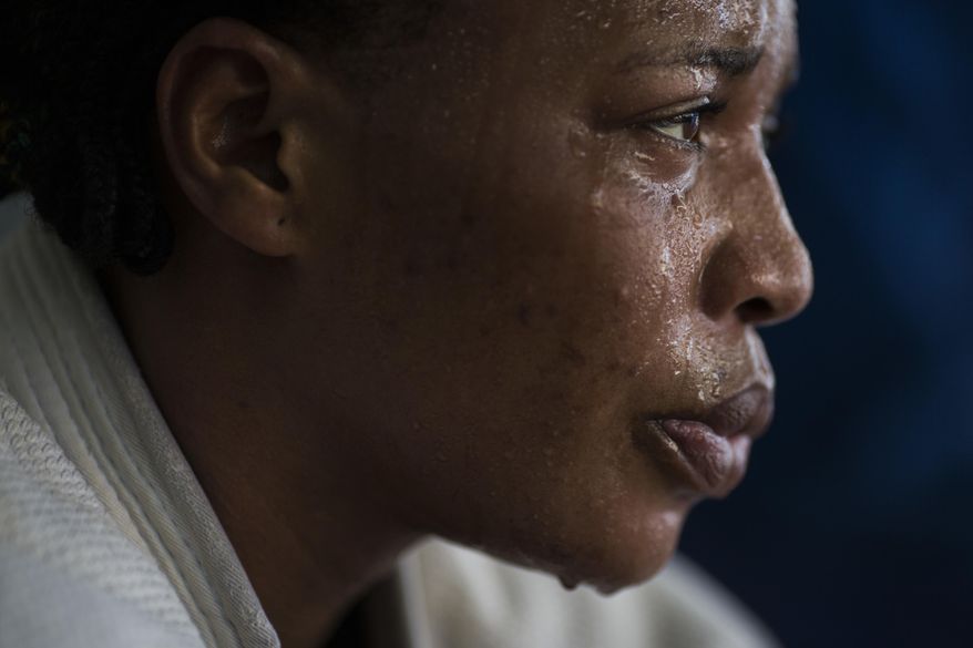 In this May 26, 2016 photo, Yolande Mabika, a refugee from the Democratic Republic of Congo, takes a break during Judo training at the Reacao Institute in Rio de Janeiro, Brazil, as she trains in hopes of making the cut for the first Olympic team of refugee athletes. In 2013, Mabika and another judo athlete from Congo traveled to Brazil with the team to compete at the World Judo Championships. They say officials left them at their downtown Rio hotel for three days prior to the competition without food, money or passports. (AP Photo/Felipe Dana)