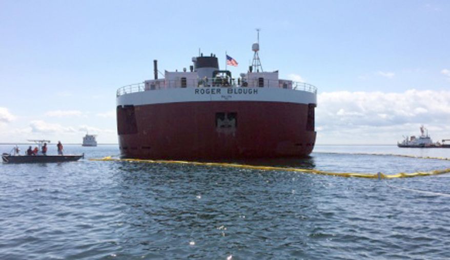 In this May 30, 2016 photo provided by the United States Coast Guard, responders place a protective boom around the stern of the motor vessel Roger Blough, that ran aground near Gros Cap Reefs Light in Lake Superior on May 27. The Coast Guard is working on plans on how it will try to free the freighter in Whitefish Bay off Michigan's Upper Peninsula. (Lt. Cmdr. Merridith Morrison/ United States Coast Guard via AP)