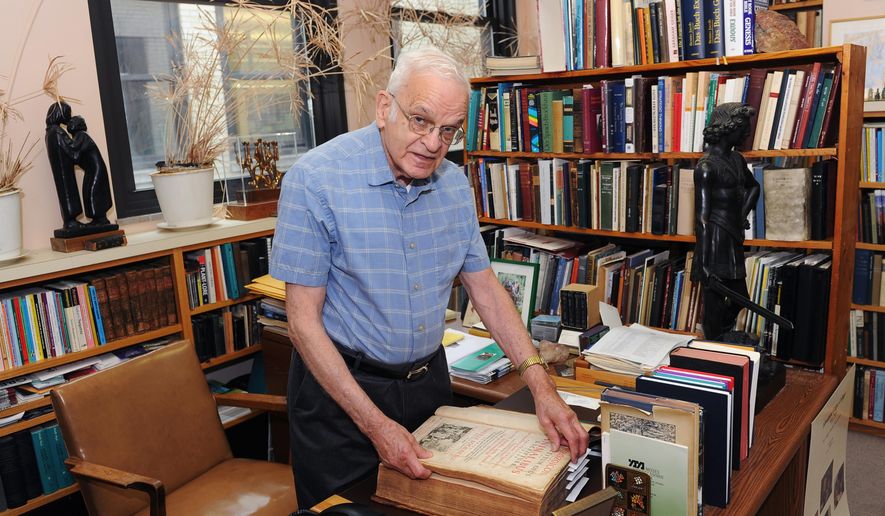 In this May 26, 2016 photo, Rabbi Walter Jacob, rabbi emeritus and senior scholar at Rodef Shalom Congregation views a Latin book on gardening inside his office in the Shadyside neighborhood of Pittsburgh. He's being honored as a pursuer of peace. (Nate Guidry/Pittsburgh Post-Gazette via AP) MAGS OUT; MONESSEN OUT; KITTANNING OUT; CONNELLSVILLE OUT; GREENSBURG OUT; TARENTUM OUT; NORTH HILLS NEWS RECORD OUT; BUTLER OUT; MANDATORY CREDIT