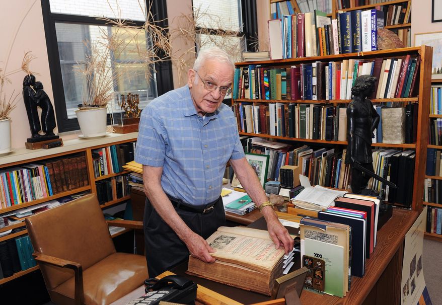 In this May 26, 2016 photo, Rabbi Walter Jacob, rabbi emeritus and senior scholar at Rodef Shalom Congregation views a Latin book on gardening inside his office in the Shadyside neighborhood of Pittsburgh. He's being honored as a pursuer of peace. (Nate Guidry/Pittsburgh Post-Gazette via AP) MAGS OUT; MONESSEN OUT; KITTANNING OUT; CONNELLSVILLE OUT; GREENSBURG OUT; TARENTUM OUT; NORTH HILLS NEWS RECORD OUT; BUTLER OUT; MANDATORY CREDIT