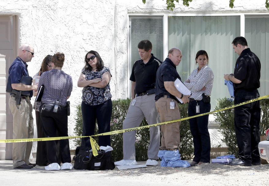 Law enforcement officials stand outside a home, Thursday, June 2, 2016 in Phoenix where three boys were killed during a several hour period Wednesday night. The boy's mother was hospitalized in critical condition with self-inflicted stab wounds according to Phoenix police. (AP Photo/Matt York)