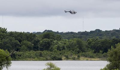 A Texas DPS helicopter flies over Lake Belton near the scene of an accident at Fort Hood at Owl Creek Park near Gatesville, Texas, on Thursday, June 2, 2016. Fort Hood says several soldiers are dead and six are missing after an Army troop truck was washed from a low-water crossing and overturned in a rain-swollen creek at Fort Hood in Central Texas. (Michael Miller/The Temple Daily Telegram via AP)