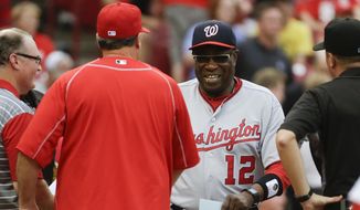 Washington Nationals manager Dusty Baker (12) shakes hands with Cincinnati Reds manager Bryan Price, center left, before a baseball game, Friday, June 3, 2016, in Cincinnati. (AP Photo/John Minchillo)