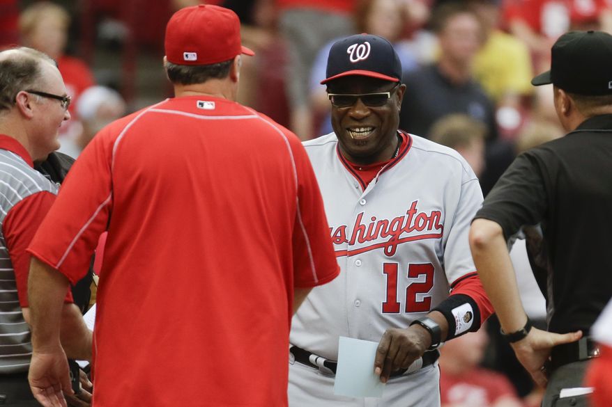 Washington Nationals manager Dusty Baker (12) shakes hands with Cincinnati Reds manager Bryan Price, center left, before a baseball game, Friday, June 3, 2016, in Cincinnati. (AP Photo/John Minchillo)