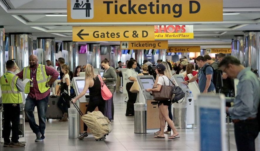 Travelers arrive at the departure terminal at LaGuardia Airport on May 27 in New York. (Associated Press)