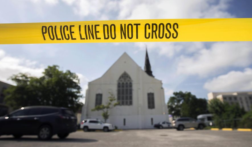 FILE - In this Friday, June 19, 2015 file photo, police tape surrounds the parking lot behind the AME Emanuel Church, a predominantly black church, as FBI forensic experts work at the crime scene where nine people where shot by white suspect Dylann Storm Roof, 21, on Wednesday in Charleston, S.C. The FBI collects extensive data on hate crimes each year, but nearly 2,800 local law enforcement agencies are not submitting the information, according to an investigation of 2009-2014 data by The Associated Press. Thousands more file reports with the FBI only sporadically. (AP Photo/Stephen B. Morton, File)