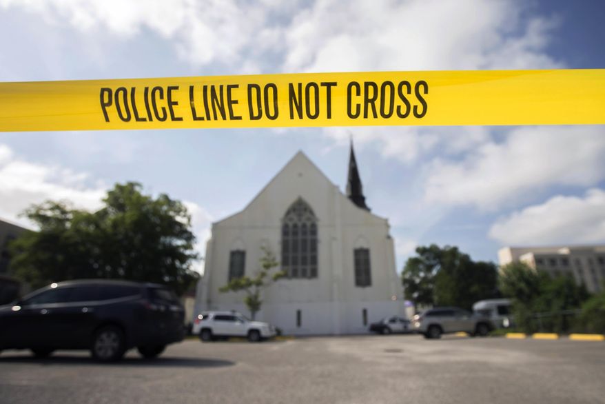 FILE - In this Friday, June 19, 2015 file photo, police tape surrounds the parking lot behind the AME Emanuel Church, a predominantly black church, as FBI forensic experts work at the crime scene where nine people where shot by white suspect Dylann Storm Roof, 21, on Wednesday in Charleston, S.C. The FBI collects extensive data on hate crimes each year, but nearly 2,800 local law enforcement agencies are not submitting the information, according to an investigation of 2009-2014 data by The Associated Press. Thousands more file reports with the FBI only sporadically. (AP Photo/Stephen B. Morton, File)