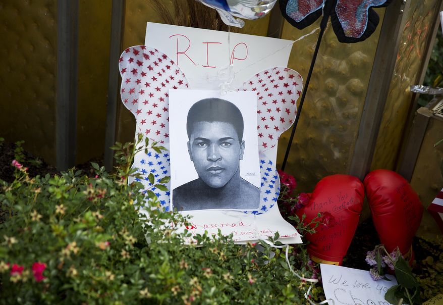 An image of Muhammad Ali and boxing gloves are left at a makeshift memorial to Ali at the Muhammad Ali Center, Monday, June 6, 2016, in Louisville, Ky. The president of Turkey and king of Jordan joined the long line of world leaders, religious figures and superstars set to speak at Ali's funeral Friday. (AP Photo/David Goldman)