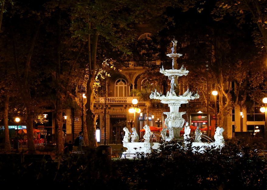 In this March 15, 2016 photo, an illuminated fountain shines bright at night in a plaza in Montevideo's Ciudad Vieja, or old city. Walking around the area is a good way to explore the varied architecture of Uruguay's capital. (Michelle Locke via AP)