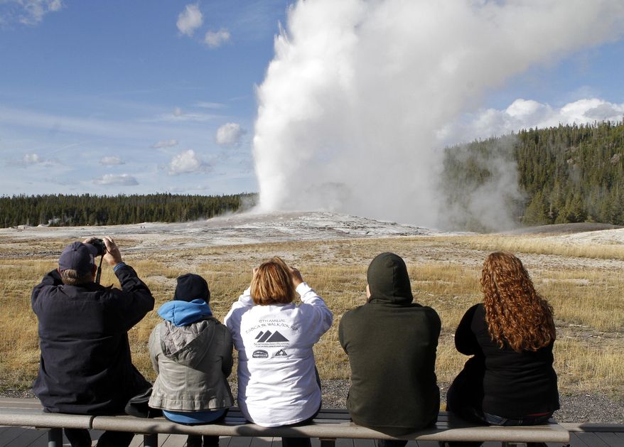 ADVANCE FOR THE WEEKEND OF JUNE 11-12 AND THEREAFTER - In a October 5, 2014 photo, tourists take in the sights and sounds of the eruption of Old Faithful in Yellowstone National Park. It was a long road, including the building of roads, from Yellowstone of 1872, through military supervision, to the creation of the National Park Service in 1916. (Raymond Hillegas/The Cody Enterprise)