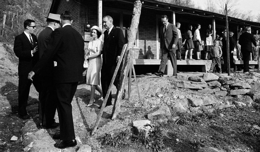 President Lyndon Johnson and his wife, Lady Bird, center left, leave the home in Inez, Ky., of Tom Fletcher, a father of eight who told Johnson he&#x27;d been out of work for nearly two years, in this April 24, 1964, photo.  The president visited the Appalachian area in Eastern Kentucky  to see conditions firsthand and announce his War on Poverty from the Fletcher porch.  (AP Photo/FILE)