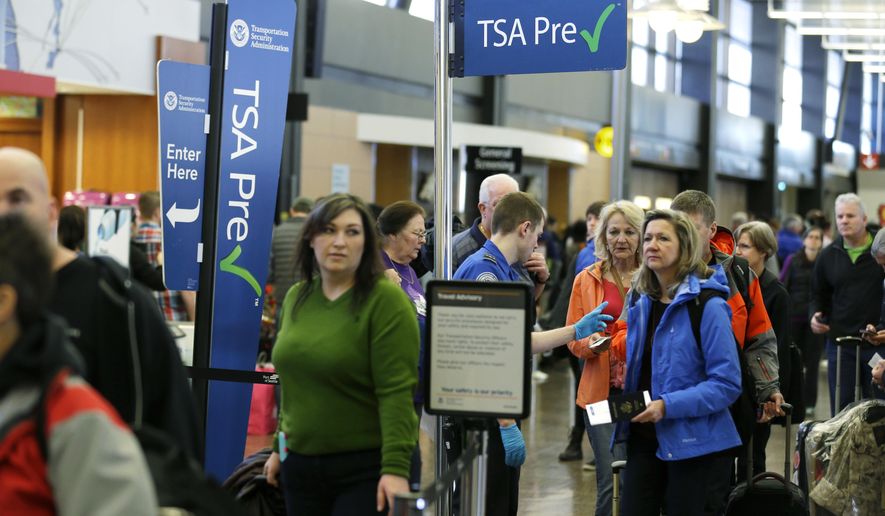 FILE - In this March 17, 2016, file photo, travelers authorized to use the Transportation Security Administration&#39;s PreCheck expedited security line at Seattle-Tacoma International Airport in Seattle have their documents checked by TSA workers. Massive lines at airports have now led to a backlog of people trying to enroll in trusted traveler programs. Waits to join PreCheck or Global Entry are months long in some cities. (AP Photo/Ted S. Warren, File)