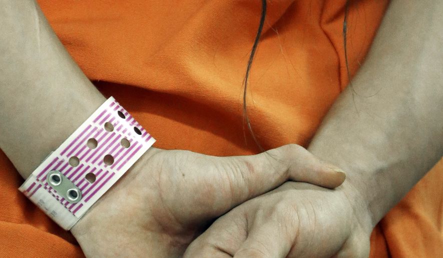 An inmate wears his special purple wrist band in a new unit in the Harris County Jail for gay, bisexual and transgender inmates in Houston on Dec. 10, 2013. (Associated Press) **FILE**