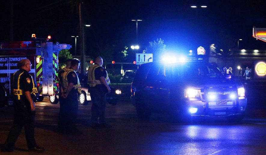 Police and Deerfield Township Fire & Rescue crew investigate the scene of a shooting from the intersection of Hwy 22 & Columbia Road on Thursday, June 9, 2016, in Landen, Ohio. Authorities say two people have been shot including a sheriff's deputy, and the alleged gunman remains on the loose. The shooting happened Thursday night in Deerfield Township, about 25 miles northeast of Cincinnati. (Sam Greene/The Cincinnati Enquirer via AP)
