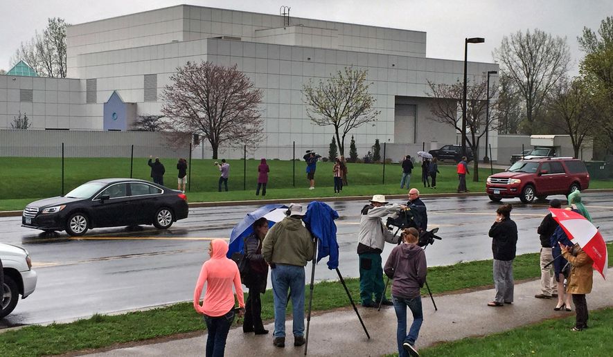 FILE - In this April 21, 2016 file photo, people stand outside entertainer Prince's Paisley Park compound in Chanhassen, Minn. Court filings in Prince's estate show that a special administrator, and likely Prince's siblings, are eager to explore the money-making potential of making a tourist attraction out of his Paisley Park home and studio complex. (Jim Gehrz/Star Tribune via AP, File) MANDATORY CREDIT; ST. PAUL PIONEER PRESS OUT; MAGS OUT; TWIN CITIES LOCAL TELEVISION OUT TV is soft out