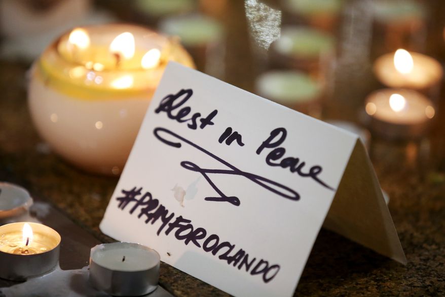 A note is placed at an impromptu candle-lit memorial set up in Sydney, Monday, June 13, 2016, following the Florida mass shooting at the Pulse Orlando nightclub where police say a gunman wielding an assault-type rifle opened fire, killing at least 50 people and wounding dozens. Australian Prime Minister Malcolm Turnbull said that the Orlando mass shooting was "an attack on all of us on all our freedoms, the freedom to gather together, to celebrate, to share time with friends." (AP Photo/Rick Rycroft)