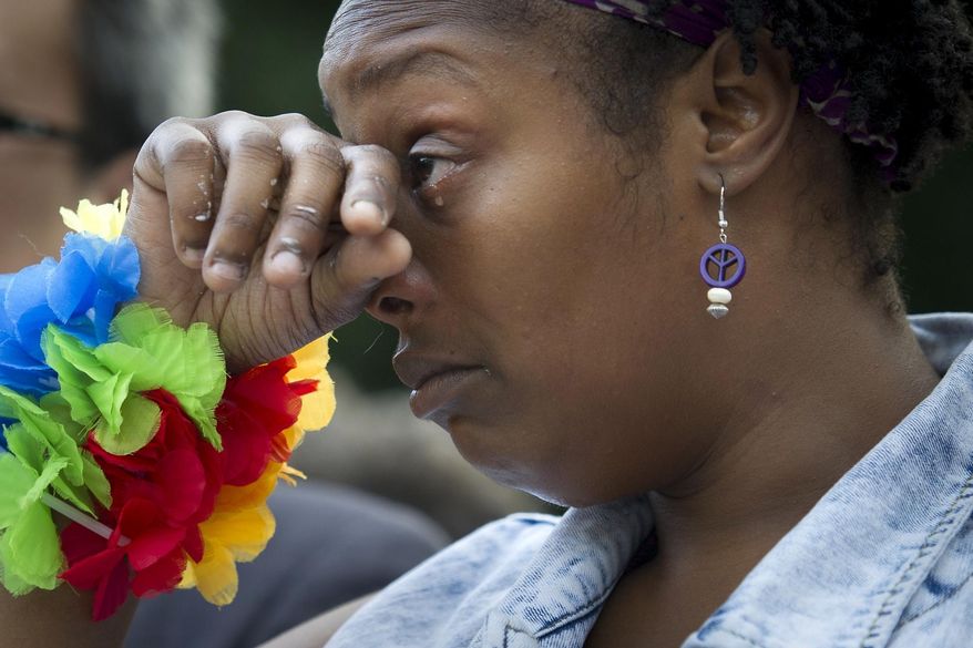 Shaniqua Evans, 29, of Washington, cries during a vigil in Washington, Monday June 13, 2016, hosted by the Muslim American Women's Policy Forum, in memory of the victims of the Orlando mass shooting. A gunman opened fire inside a crowded gay nightclub early Sunday, before dying in a gunfight with SWAT officers, police said. (AP Photo/Cliff Owen)