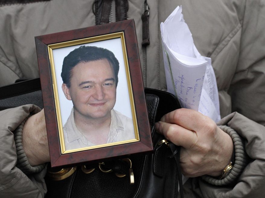 FILE - In this Nov. 30, 2009, file photo a portrait of lawyer Sergei Magnitsky, who died in jail, is held by his mother Nataliya Magnitskaya, as she speaks during an interview with the AP in Moscow. A documentary premiering June 13, 2016, at Washington’s Newseum is generating controversy by claiming that late Russian whistleblower Magnitsky, who had inspired a major U.S. human rights law, was responsible for the very fraud he had accused Russian officials of perpetrating. (AP Photo/Alexander Zemlianichenko, File)