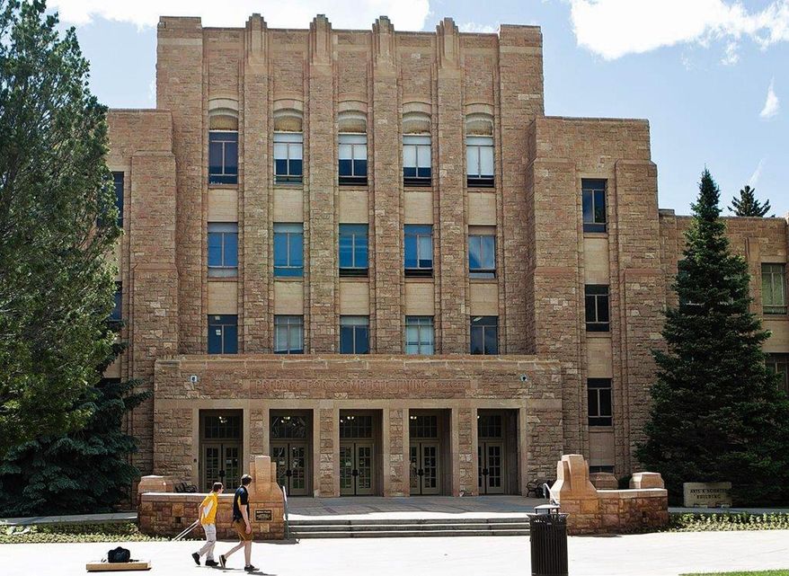 Two people walk on the University of Wyoming campus on Tuesday, June 14, 2016. The state's only public four-year university is having to find more than $40 million in savings over the next two years because of cuts in state aid caused by the drop in revenue from Wyoming's coal, oil and natural gas industry. The UW Board of Trustees was meeting Wednesday to address the cuts. (Shannon Broderick/Laramie Boomerang via AP)