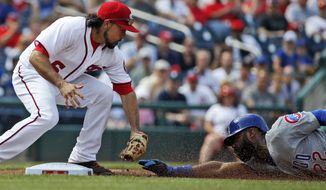 Washington Nationals third baseman Anthony Rendon reaches to tag out Chicago Cubs&#39; Jason Heyward while attempting to steal third base base in first inning Wednesday. (AP Photo/Alex Brandon)