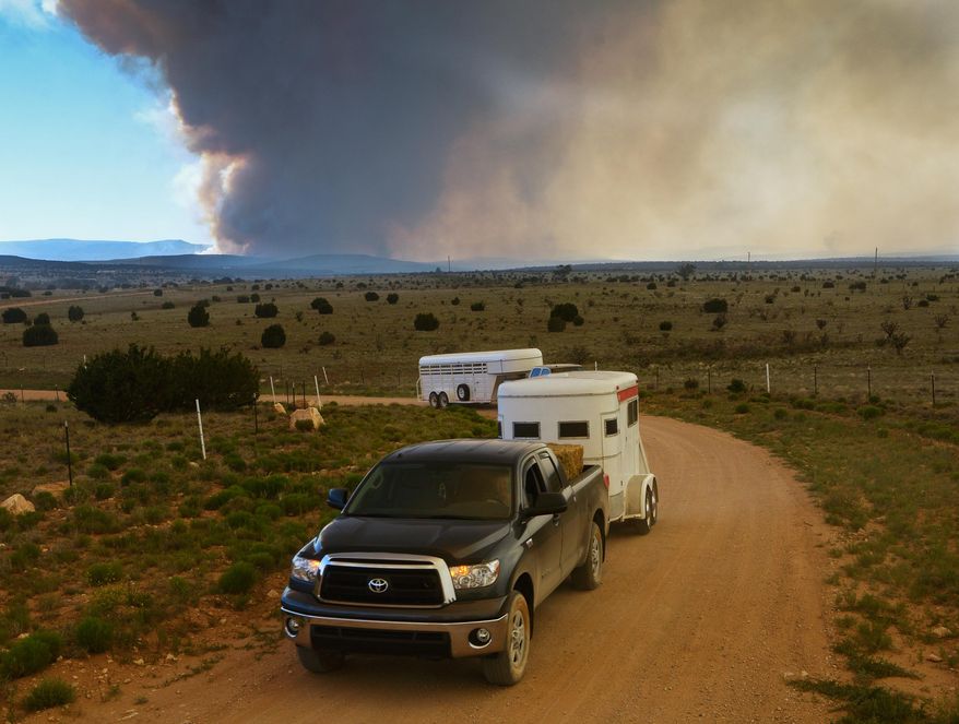 East mountain residents evacuate their homes as the Dog Head Fire burns on Thursday, June 16, 2016 in Albuquerque, N.M. Firefighters struggled Thursday to make progress against a fast-moving wildfire in central New Mexico as it consumed tinder dry forest, sent up a towering plume of smoke that could be seen for miles, and forced more residents from their homes. (Greg Sorber/The Albuquerque Journal via AP) MANDATORY CREDIT