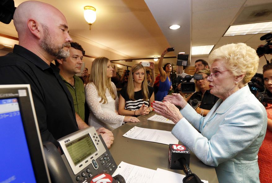 FILE - In this Friday, June 26, 2015 file photo, Hinds County Circuit Clerk Barbara Dunn, right, reads an order by Mississippi Attorney General Jim Hood that puts a hold on circuit clerks from issuing marriage licenses to same sex couples, including, from left, Duane Smith and Knol Aust, both of Jackson, Miss., and Laurin Locke and Tiffany Brosh, at the Hinds County Court House in Jackson, Miss. They were able to get married three days later. (AP Photo/Rogelio V. Solis)