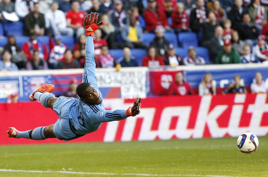 D.C. United goalkeeper Bill Hamid dives for a shot by the New York Red Bulls during the first half of an MLS playoff soccer match, Sunday, Nov. 8, 2015, in Harrison, N.J. The shot went wide of the goal. (AP Photo/Julio Cortez)