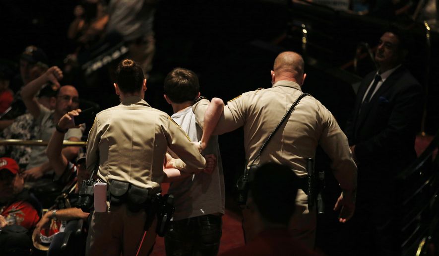 Police remove a protester as Republican presidential candidate Donald Trump speaks at the Treasure Island hotel and casino Saturday in Las Vegas. (Associated Press)