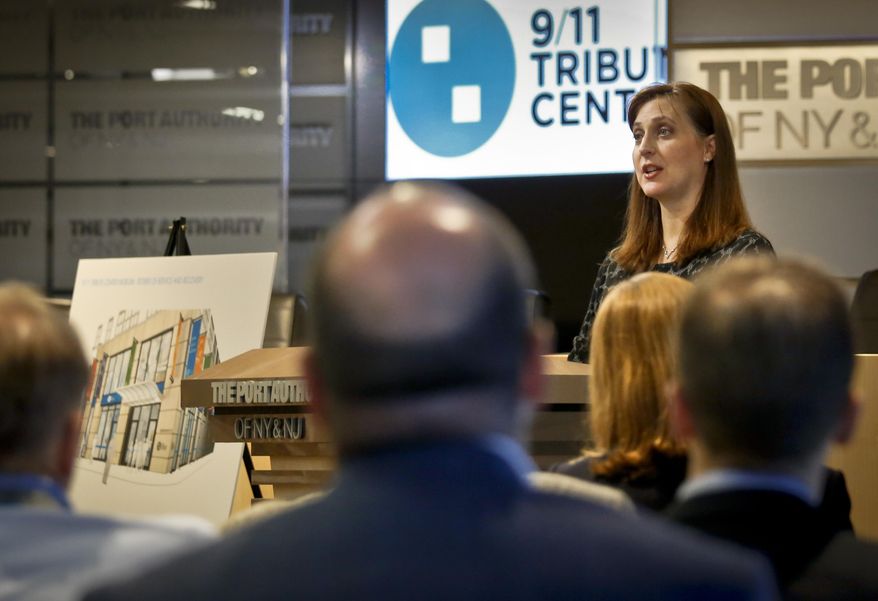 Jennifer Adams-Webb, right, CEO and co-founder for the September 11 Tribute Center, stands next to a rendering of the center's new museum, left, during a press conference, Tuesday, June 21, 2016, in New York. The Sept 11 Tribute Center, an exhibition center depicting events of 9/11, will move to a new expanded location near the World Trade Center. (AP Photo/Bebeto Matthews)