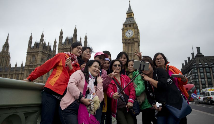 Tourists take a selfie backdropped by the Houses of Parliament in London, Wednesday, June 22, 2016. Britain votes whether to stay in the European Union in a referendum on Thursday. (AP Photo/Matt Dunham)