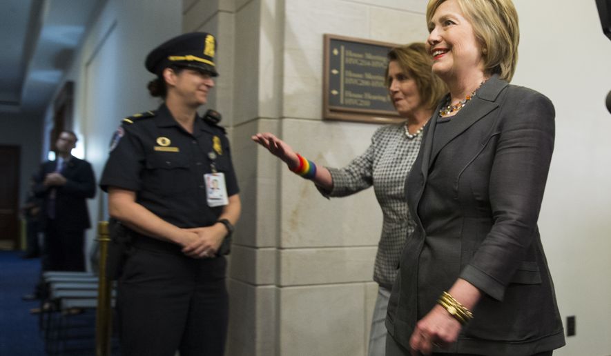 Democratic presidential candidate Hillary Clinton is escorted by House Minority Leader Rep. Nancy Pelosi of Calif. to a House Democratic caucus meeting on Capitol Hill in Washington, Wednesday, June 22, 2016. (AP Photo/Evan Vucci)